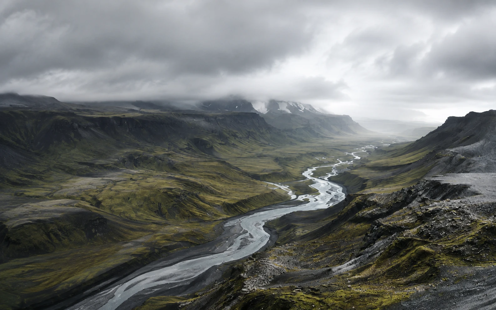 An Icelandic glacial river running between moss-covered mountains